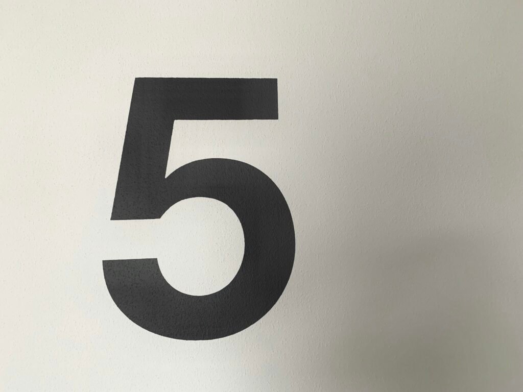 Schwarz-weißes Foto einer großen Zahl 9 auf hellem Hintergrund, minimalistische und klare Typografie-Ästhetik