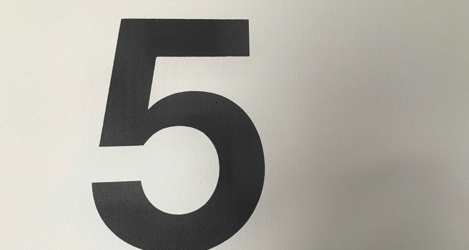 Schwarz-weißes Foto einer großen Zahl 9 auf hellem Hintergrund, minimalistische und klare Typografie-Ästhetik