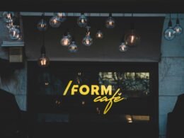 Schwarz-weiße Pendelleuchten in minimalistischem Design hängen von der Decke in einem modernen Raum.