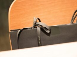 Schwarze Einkaufstasche aus Papier mit schwarzer Schleife, stehend auf hellem Hintergrund, geeignet für E-Commerce Themen