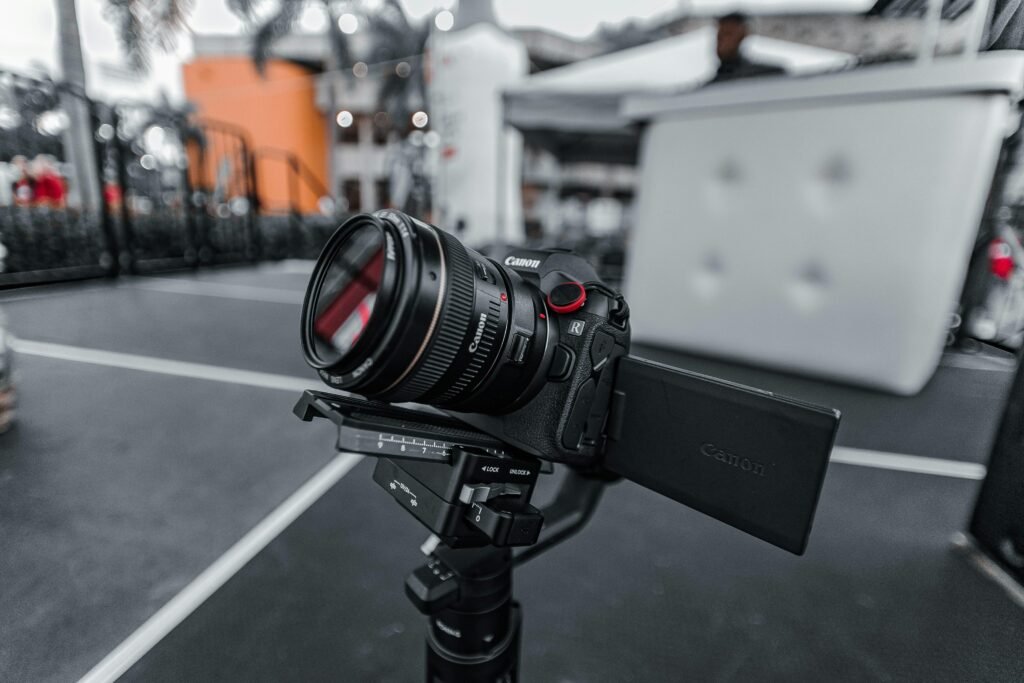 Schwarze Nikon DSLR-Kamera auf schwarzem Stativ vor dunklem Hintergrund, geeignet für hochwertige Fotoaufnahmen mit moderner Technik