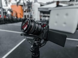 Schwarze Nikon DSLR-Kamera auf schwarzem Stativ vor dunklem Hintergrund, geeignet für hochwertige Fotoaufnahmen mit moderner Technik