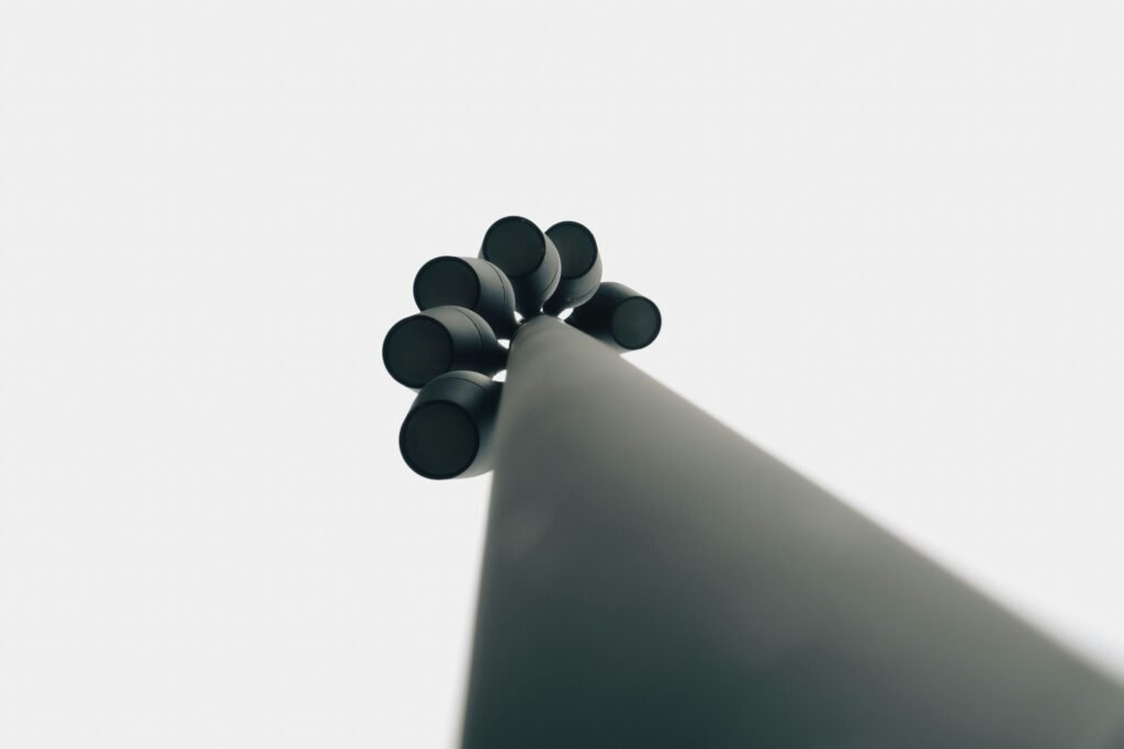 Schwarze Objekte liegen auf einer weißen Fläche in stilvoller, minimalistischer Anordnung