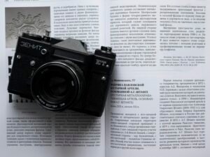 Schwarze und silberne Nikon DSLR Kamera liegt auf weißem Druckerpapier, Fokus auf Technik und Design.