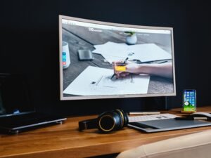 Schwarzer Flachbildfernseher steht auf einem braunen Holztisch in einem modern eingerichteten Raum