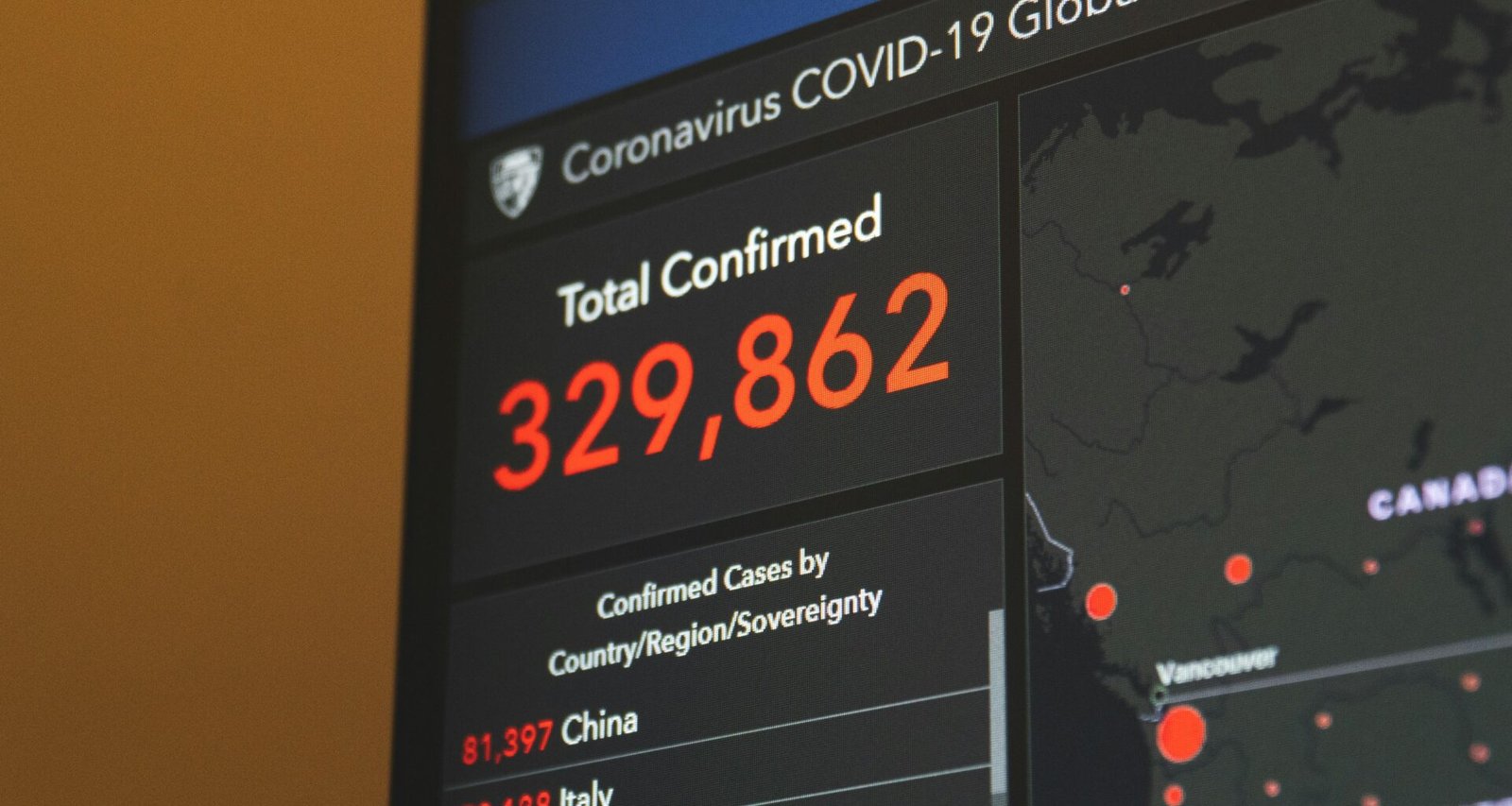 Schwarzer Flachbildfernseher mit sichtbar eingeschaltetem Bildschirm, nah aufgenommen, vor neutralem Hintergrund
