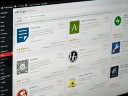 Flacher, schwarzer Computerbildschirm auf Schreibtisch in moderner Büroumgebung, ideal für IT und Online-Marketing.