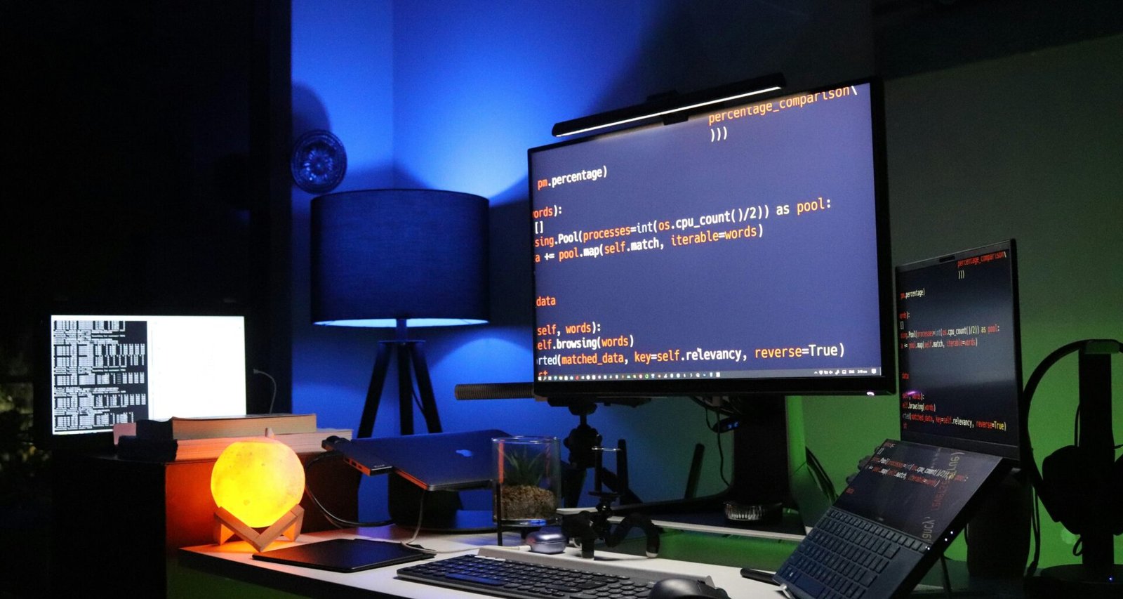 Schwarzer Flachbildschirm-Computer auf einem grünen Schreibtisch in modernem, minimalistischem Arbeitsumfeld