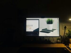 Ein schwarzer Flachbildschirm-Computer zeigt eine geöffnete Facebook-Seite in einer modernen Arbeitsumgebung.