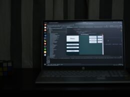 Schwarzes HP Laptop mit aufgeklapptem Display und sichtbarem Desktop auf einem Tisch