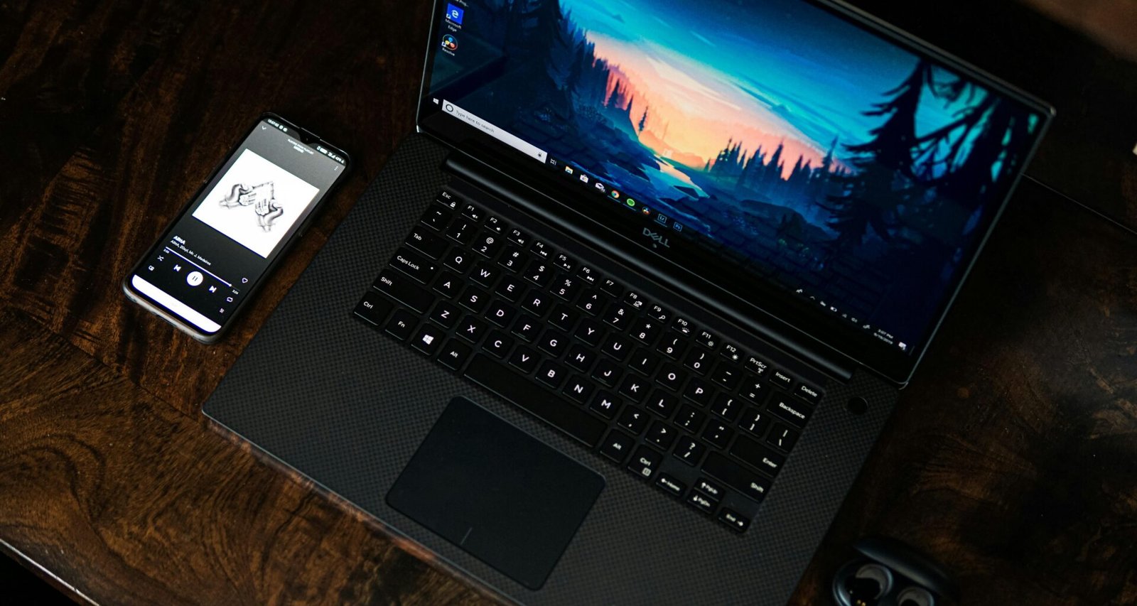 Schwarzes Laptop auf einem aufgeräumten Schreibtisch mit minimalistischer Gestaltung und technischem Arbeitsumfeld