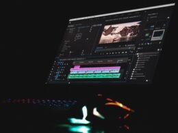 Schwarzer Laptop mit eingeschaltetem Bildschirm, auf dem ein Musikplayer läuft, auf einem Tisch platziert