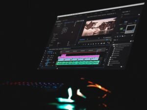 Schwarzer Laptop mit eingeschaltetem Bildschirm, auf dem ein Musikplayer läuft, auf einem Tisch platziert