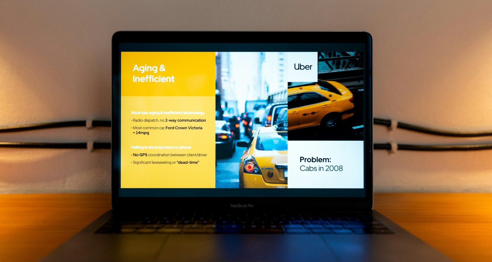 Ein aufgeklappter schwarzer Laptop zeigt einen Mann im gelben Hemd auf dem Bildschirm während einer Präsentation.