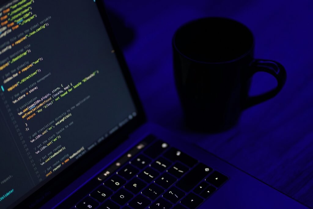 Schwarzes aufgeklapptes Laptop neben einer schwarzen Keramiktasse auf einem Arbeitstisch, ideal für Homeoffice oder Online-Arbeit.