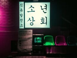 Schwarze Slotmaschine mit hellen Displays, platziert neben einem einzelnen Stuhl in einem modernen Casino-Setting