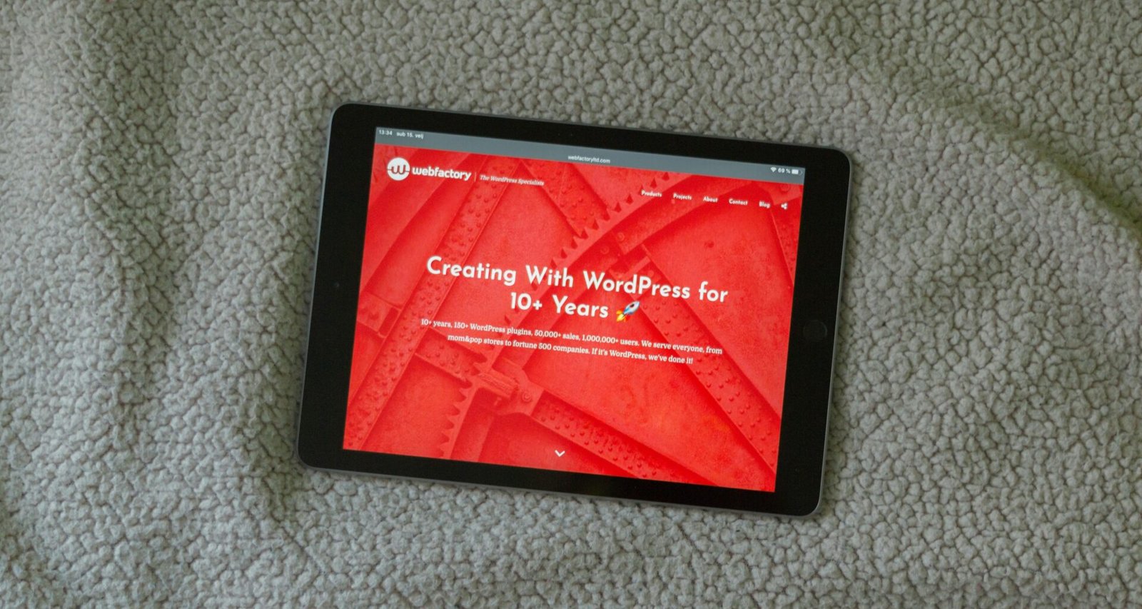 Schwarzes Tablet auf grauem Textiluntergrund zeigt die Verbindung von Technik und Alltag in einer stilvollen Umgebung.