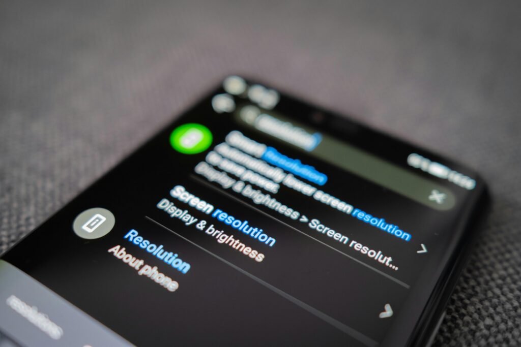 Schwarzes Android-Smartphone auf grauem Textil, neutral arrangiert, geeignet für Artikel zu Technologie, Online-Marketing oder mobile Endgeräte.