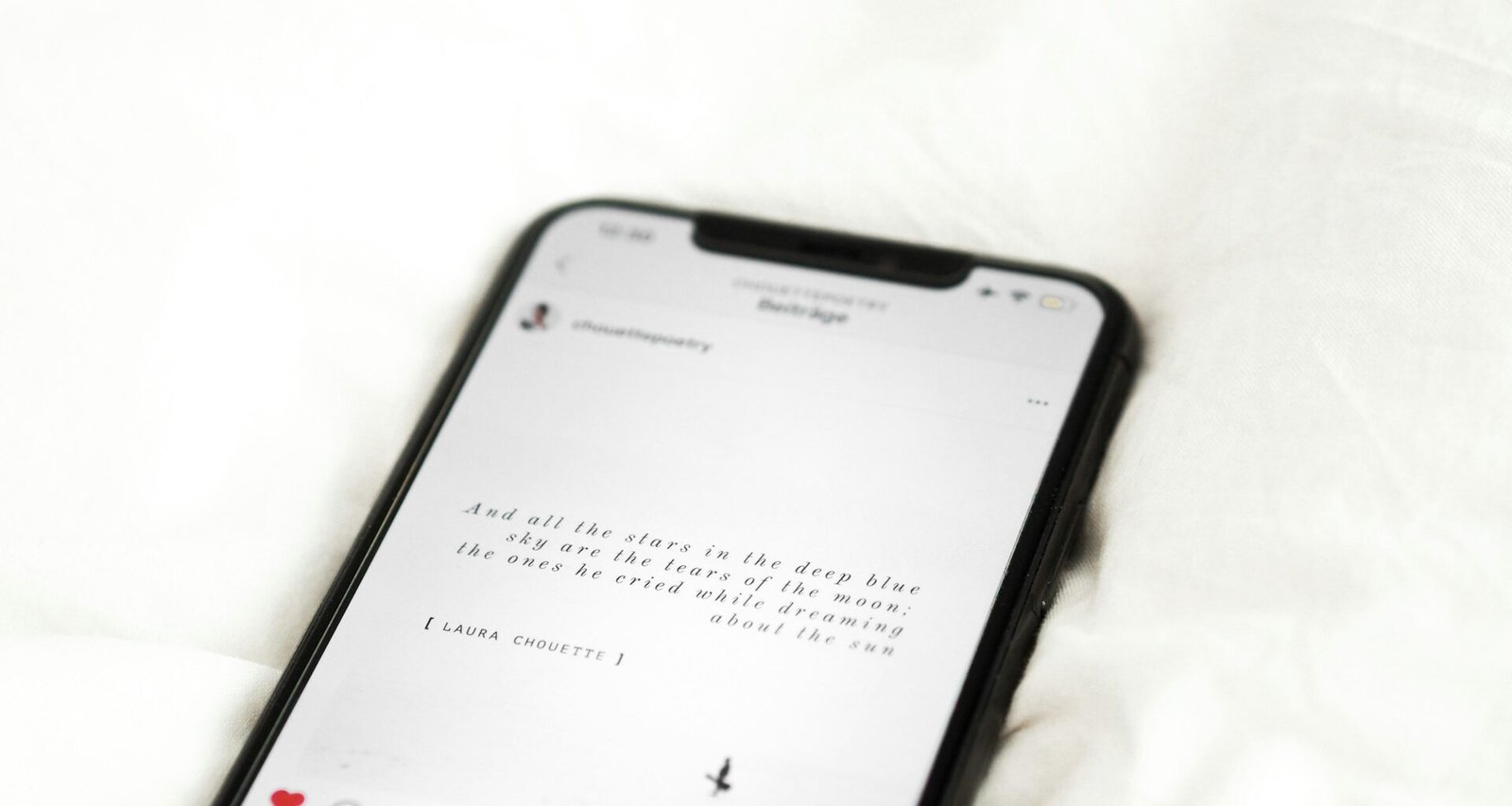 Schwarzes Android-Smartphone auf weißem Textilstoff, Draufsicht, geeignet für Technik- und Mobile-Artikelabbildungen