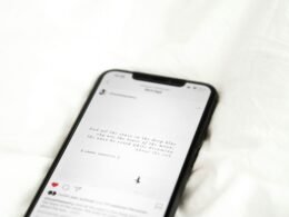 Schwarzes Android-Smartphone auf weißem Textilstoff, Draufsicht, geeignet für Technik- und Mobile-Artikelabbildungen