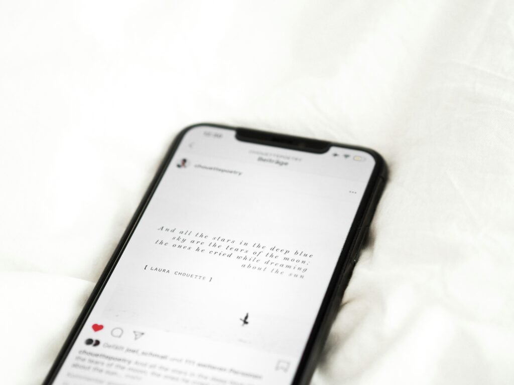 Schwarzes Android-Smartphone auf weißem Stoff, Nahaufnahme als Symbolbild für digitale Technologien