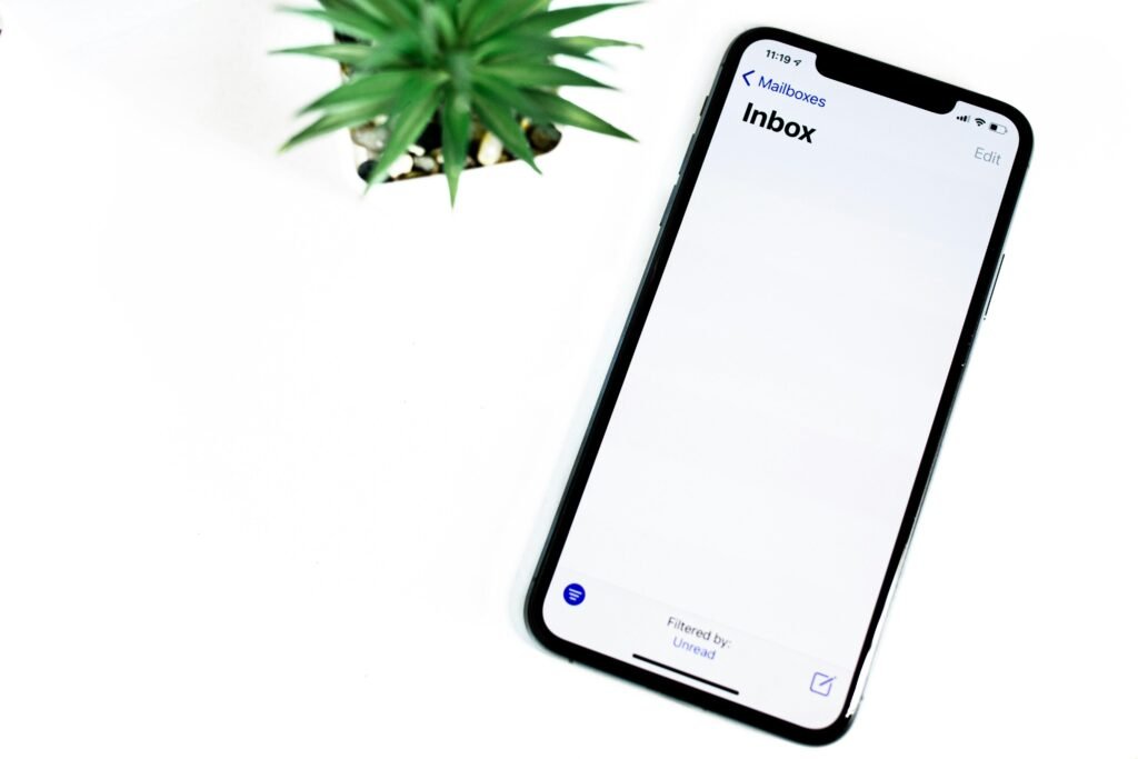 Schwarzes iPhone 5 liegt flach auf einer weißen Oberfläche mit klarem, minimalistischem Hintergrund