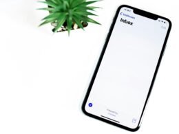 Schwarzes iPhone 5 liegt flach auf einer weißen Oberfläche mit klarem, minimalistischem Hintergrund