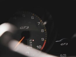 Schwarze Fahrzeug-Instrumententafel mit digitalem Tacho, klar ablesbaren Anzeigen und Lenkradausschnitt im Vordergrund