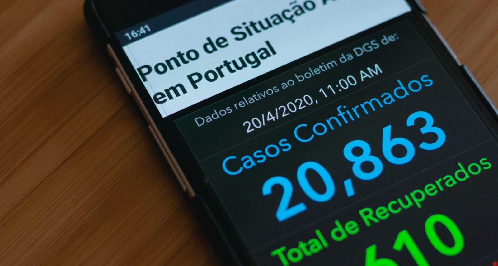 Ein schwarzes Samsung Android Smartphone liegt auf einem braunen Holztisch in einer ruhigen Umgebung.