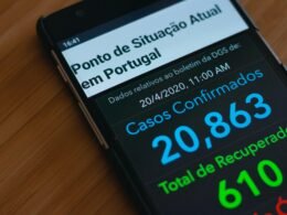 Ein schwarzes Samsung Android Smartphone liegt auf einem braunen Holztisch in einer ruhigen Umgebung.