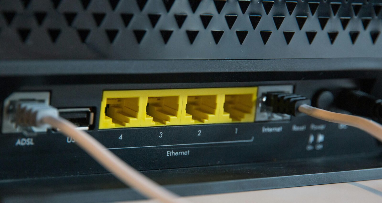 Schwarzes elektronisches Gerät mit Kabel auf weißem Hintergrund, Detailaufnahme, Technikthema