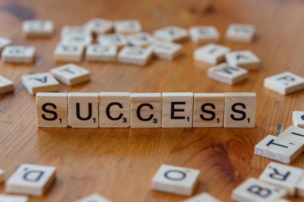 Scrabble-Spielsteine, die das Wort Success formen, arrangiert auf einer hölzernen Tischoberfläche