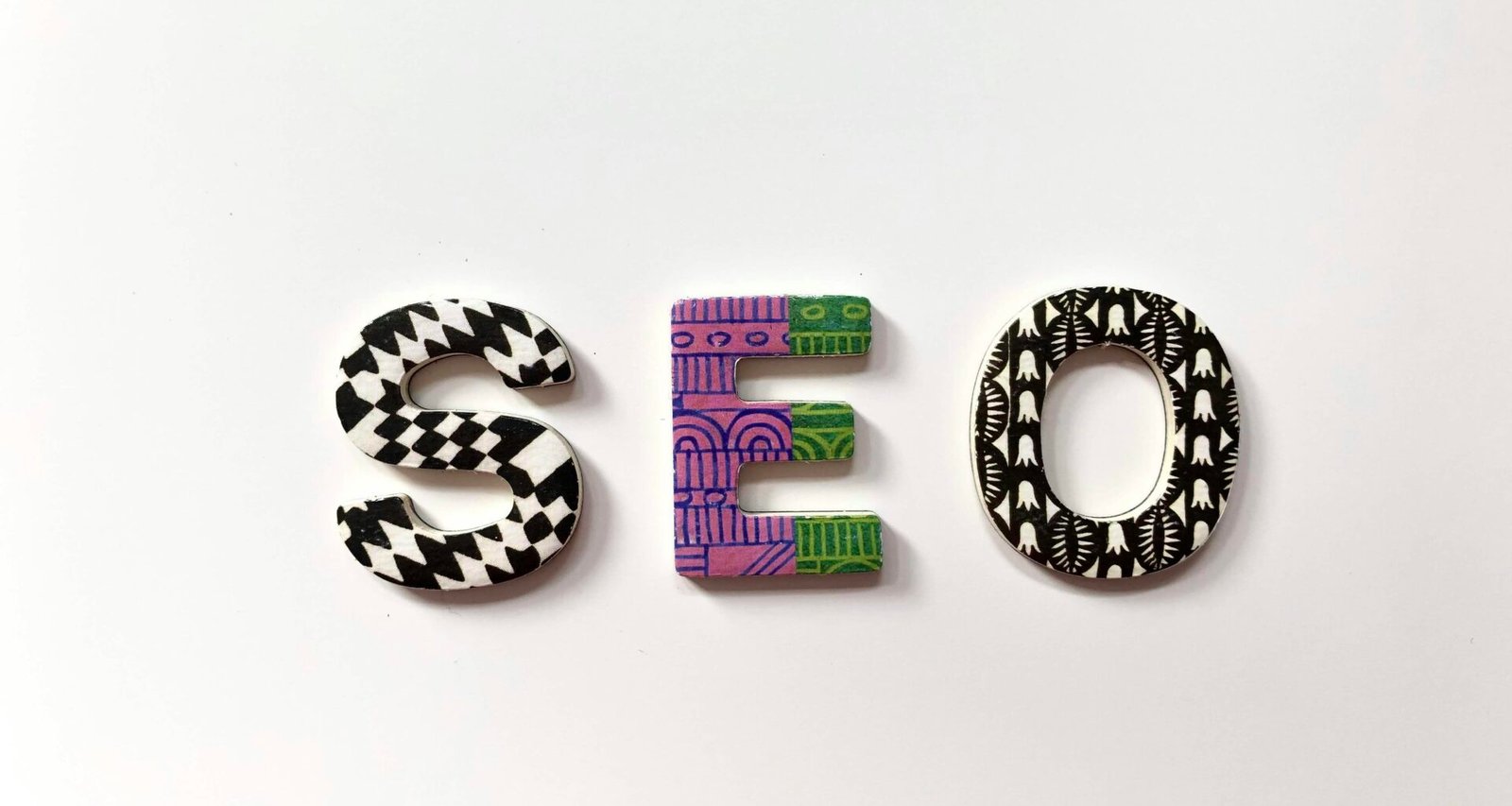 Farbige SEO Text-Grafik mit stilisierten Buchstaben auf hellem Hintergrund, Symbolbild für digitale Optimierung