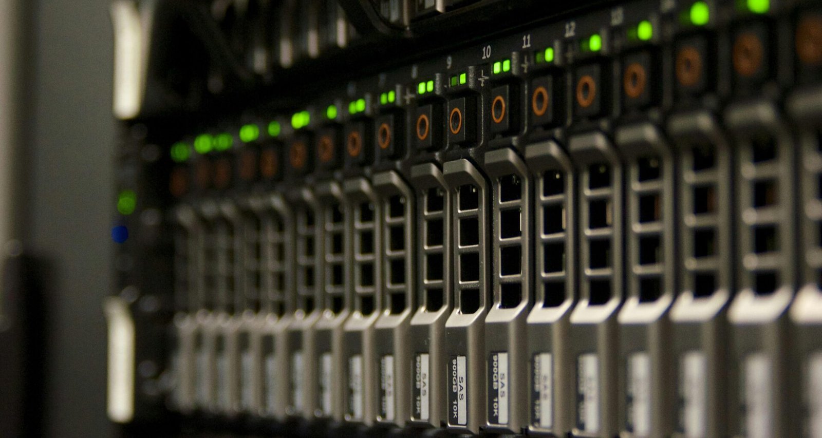 Server-Rack mit mehreren Hardwarekomponenten und grün blinkenden LEDs in einem professionellen Rechenzentrum.