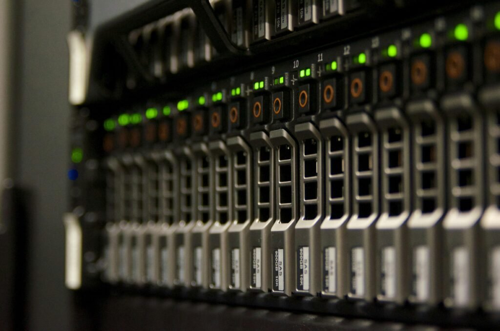 Server Rack mit mehreren Geräten und grünen LED-Anzeigen, die in einem modernen Rechenzentrum aktiv sind