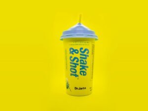 Shake and Shot Becher mit Deckel, stehend auf einer Oberfläche, fotografiert als Konzept für Verpackungsdesign