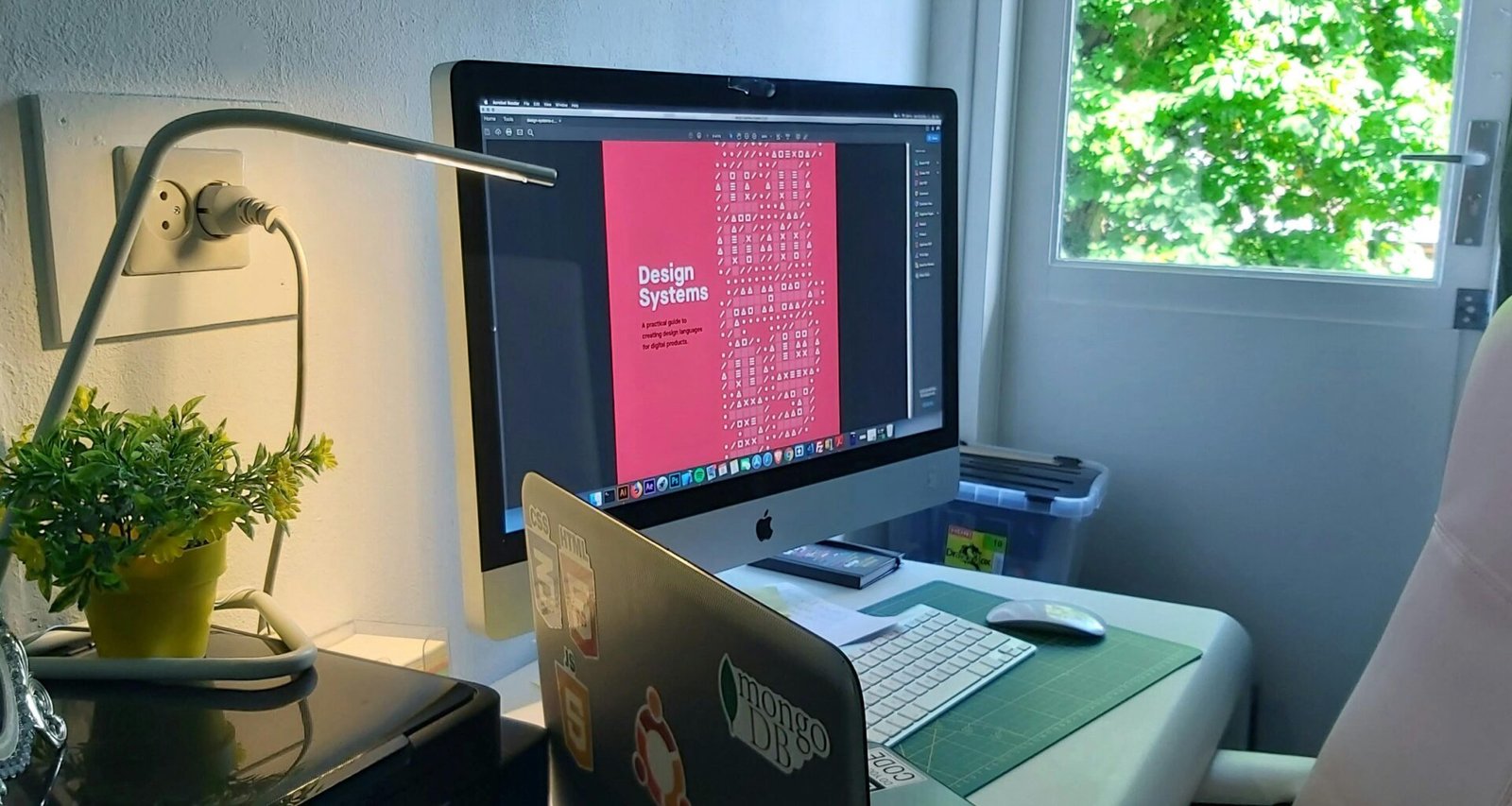 Silberner Apple iMac auf einem Schreibtisch mit Tastatur und Maus, moderner Arbeitsplatz in neutraler Umgebung