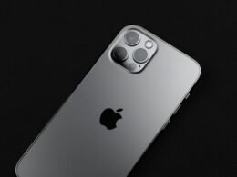 Silbernes iPhone 6 auf schwarzer Fläche, minimalistisch fotografiert und fokussiert auf das elegante Smartphone-Design