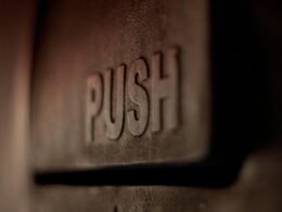 Detailaufnahme eines silbernen Wanddekors mit geprägtem Love-Schriftzug auf strukturierter Oberfläche