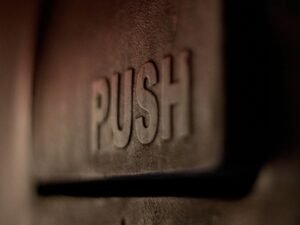 Detailaufnahme eines silbernen Wanddekors mit geprägtem Love-Schriftzug auf strukturierter Oberfläche