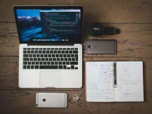 Ein eingeschaltetes silbernes MacBook auf einem Tisch, geöffnet und bereit zur Arbeit, ideal für digitale Projekte und Technikartikel