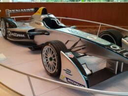 Silberner Formel-E-Rennwagen steht ausgestellt auf einer Motorsportveranstaltung, Elektroauto im Fokus.
