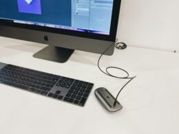 Silberner Apple iMac neben Apple Magic Keyboard und Magic Mouse auf einem Schreibtisch, minimalistisches Tech-Setup
