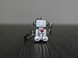 Silberner und schwarzer Roboter als Spielzeug, stehend auf glatter Oberfläche, Vorderansicht mit künstlichen Details