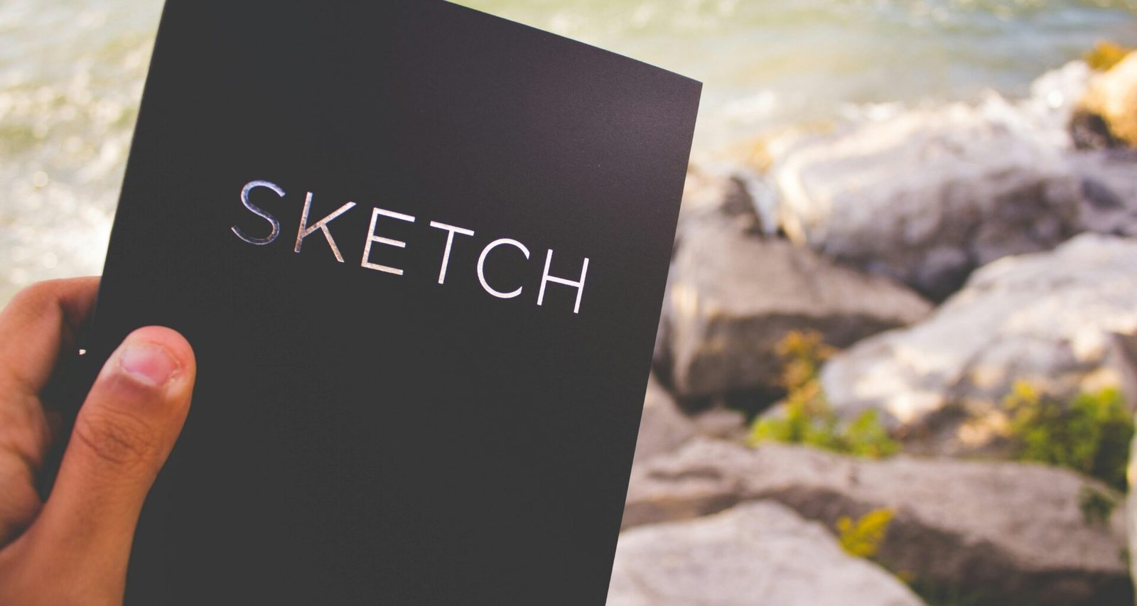 Eine geöffnete Skizzenbox mit verschiedenen Zeichenutensilien liegt auf einem Tisch, bereit für kreative Projekte