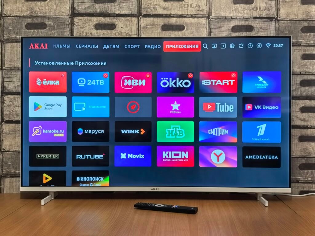 Smart TV Bildschirm mit verschiedenen App-Symbolen für Streaming, Spiele und Unterhaltung, fotografiert in moderner Wohnumgebung.