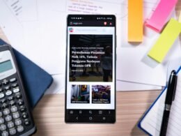 Smartphone liegt auf einem Schreibtisch neben einem Taschenrechner und bunten Haftnotizen, moderner Arbeitsbereich