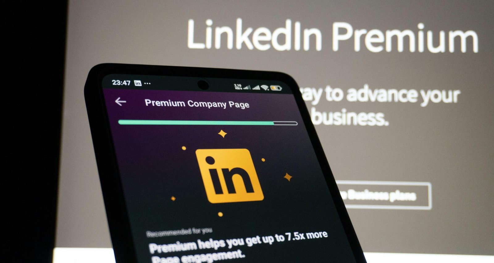 Ein Smartphone liegt auf einem Tisch und zeigt die LinkedIn Premium-Seite im Vordergrund deutlich an.