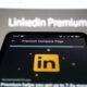 Smartphone zeigt die Benutzeroberfläche von LinkedIn Premium mit Einblick in Profildetails und Funktionen.