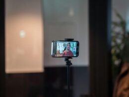 Ein Smartphone auf einem Stativ nimmt eine einzelne Person auf, ideal für Content-Produktion oder Social Media Aufnahmen.